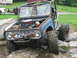 1992 Ford Mustang - This heavily modified off-road buggy navigates a rocky terrain, a prominent roll cage and a front-mounted winch.