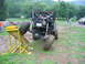 1992 Ford Mustang - A custom-built off-road buggy navigates a challenging obstacle course, with one wheel elevated on a yellow ramp.