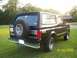 1993 Ford Bronco - Rear view of a black 1993 Ford Bronco with a spare tire on the back, parked on a grassy lawn.
