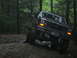 1992 Ford Mustang - This Ford F-Series truck navigates a muddy off-road path through a forest.