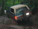 1992 Ford Mustang - A Ford Bronco is shown navigating a rocky, off-road trail with trees in the background.