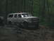 1992 Ford Mustang - This Ford Bronco is navigating a challenging off-road path through a dense forest.