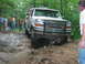1992 Ford Mustang - White Ford Bronco tackling a challenging off-road course in a wooded area.