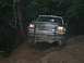 1992 Ford Mustang - Ford F-Series truck navigates a challenging off-road path through a forest.