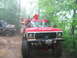 1992 Ford Mustang - Modified red Ford pickup truck with a man on top, driving off-road with another vehicle.