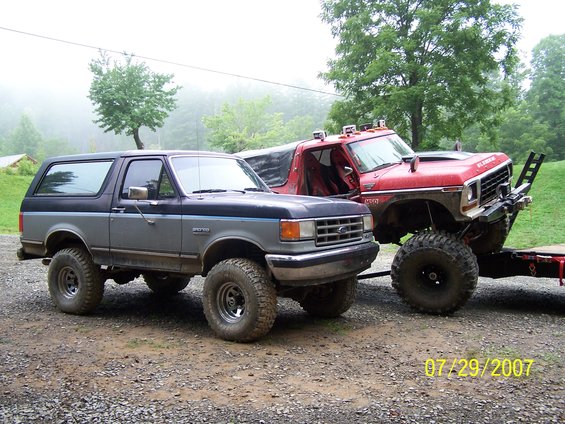 Gray and black Bronco next to a lifted red Bronco on a trailer. Date stamp reads 07/29/2007