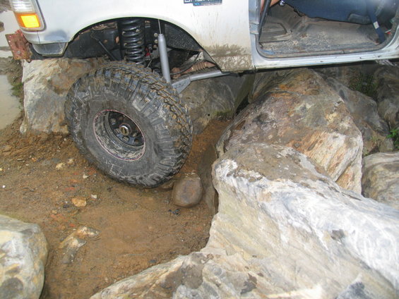 Silver 1995 Ford C-350 (Centurion Conversions) front wheel on rocks