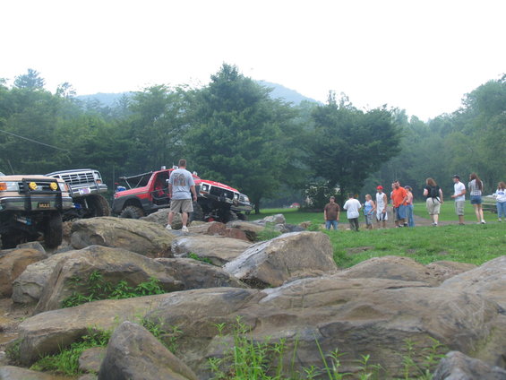 Off-road vehicles on rocky terrain with spectators