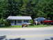 1994 Ford F-250 - A lifted red pickup truck is parked in front of a house with other vehicles nearby.