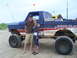 1994 Ford F-250 - A couple stands on a sandy beach next to a heavily modified pickup truck with "DAMAGE INC" graphics.