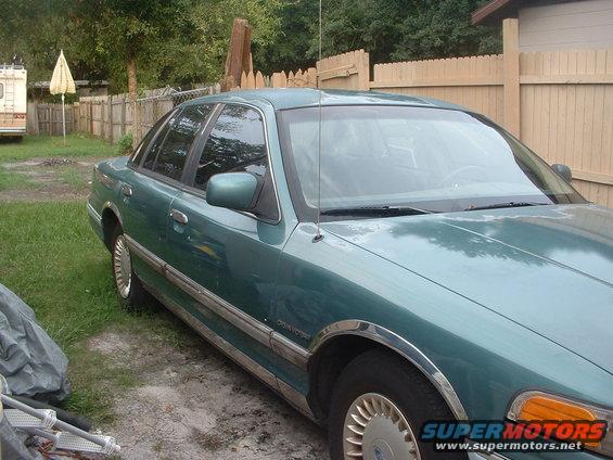 Green 1993 Ford Crown Victoria sedan, 3/4 front view, parked in a yard