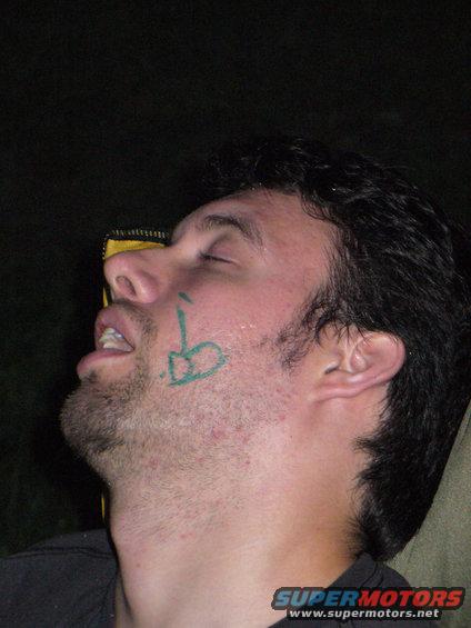 Man with green drawing on his face, eyes closed