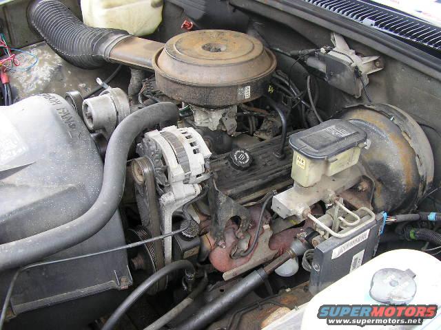 Engine bay with V8 engine, carburetor, alternator, and brake fluid reservoir