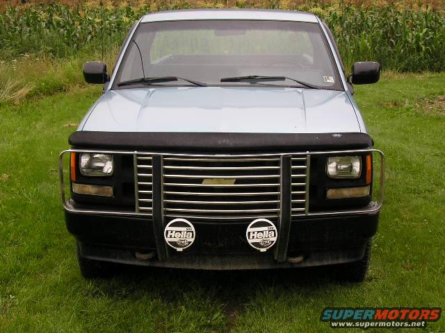 Light blue pickup truck front view with chrome grille and Hella fog lights
