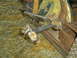 2005 Ford Excursion - A single, rusty suspension part lies on a carpeted surface, surrounded by other items.
