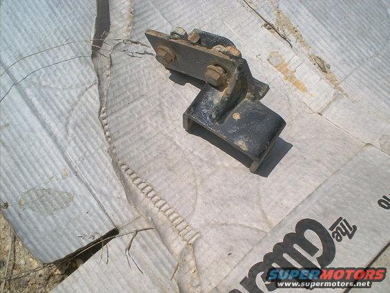 Metal bracket with bolts, resting on cardboard