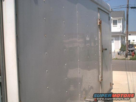 Gray trailer side with rivets and a door