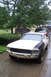 1968 Ford Mustang - A 1968 Ford Mustang is parked in a driveway, showing its front end with a two-tone paint scheme.