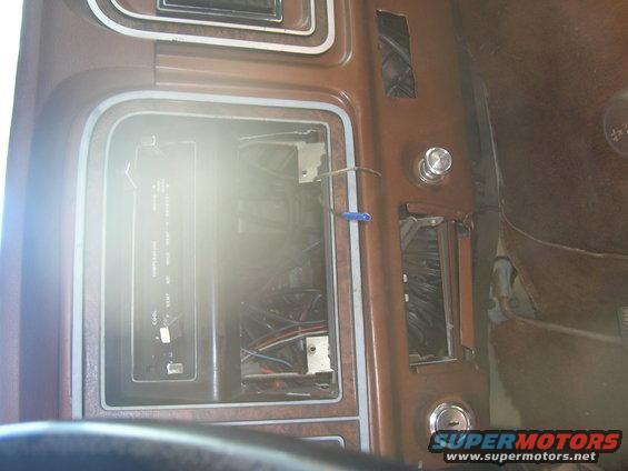 Interior shot of a vehicle's center console with the radio and other components removed, exposing wiring