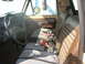 1978 Ford Bronco - The interior of a 1978 Ford Bronco features striped cloth seats and a blanket covering the bench seat.
