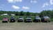 1985 GMC Jimmy - A lineup of off-road vehicles, including trucks and SUVs, are parked on a grassy field.