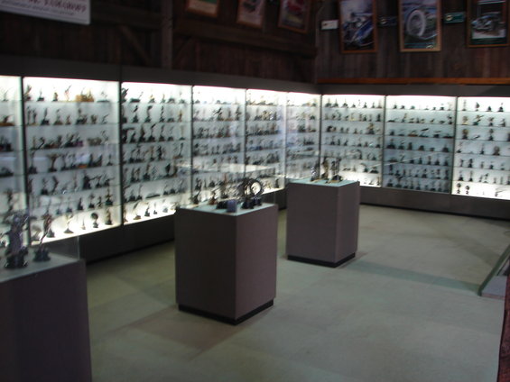Museum display cases filled with miniature models, with framed pictures on the wall
