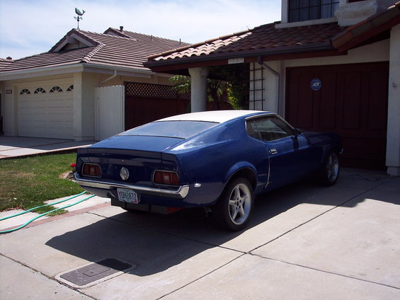 Blue 1971 Ford Mustang fastback with white roof parked in driveway
