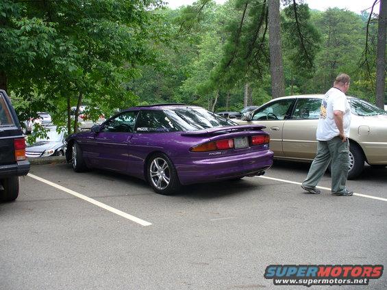 Purple 1991 Ford Probe parked in a lot with a man walking by