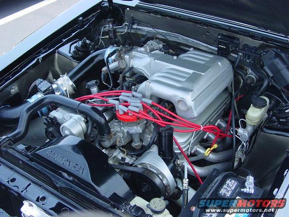 1986 Ford Mustang engine bay with silver intake manifold and red spark plug wires