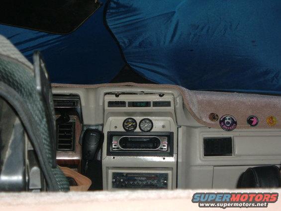 Dashboard with aftermarket radio, gauges, and a CB radio. Blue sunshade is visible