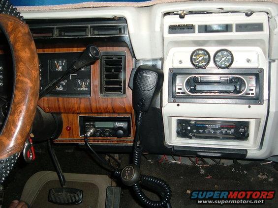 Dashboard interior of a 1980s Ford Bronco showing gauges, CB radio, and stereo