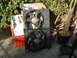 1994 Jeep YJ - Dual radiator fan assembly with wiring, outdoors next to plants and boxes.