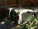 1994 Jeep YJ - A Jeep hardtop is stored outdoors, partially covered by shadows and grass.