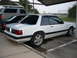 1991 Ford Mustang - A white 1991 Ford Mustang coupe is parked under a carport, viewed from the rear three-quarter angle.