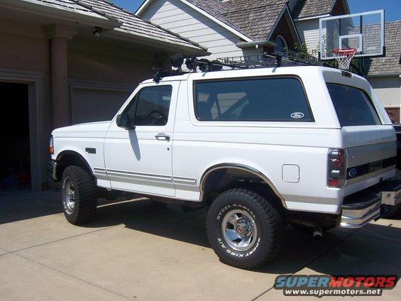 White Ford Bronco parked in driveway, roof rack installed