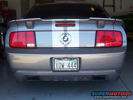 Silver 2006 Ford Mustang rear view with racing stripes and Roush badging