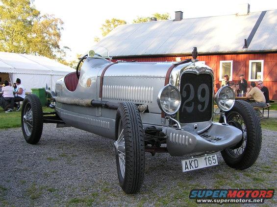 Silver race car with wire wheels, license plate AKD 165, and number 29 on the grille