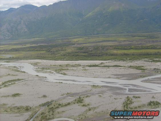 River delta landscape with mountains in background and Supermotors logo