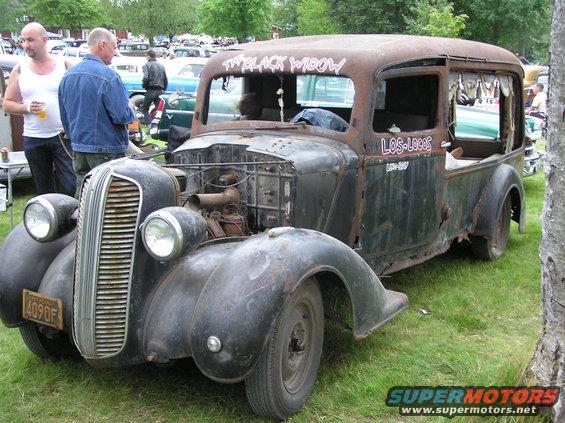 Rusty rat rod truck with "The Black Widow" and "Los Locos" painted on it