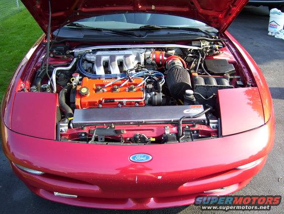 Red 1995 Ford Probe engine bay with aftermarket air intake
