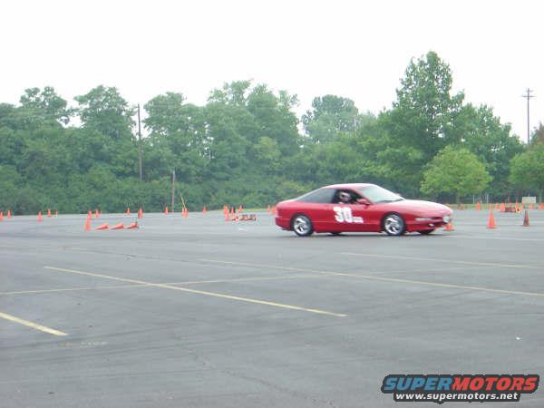 Red sports car with number 30 on the side driving on a track