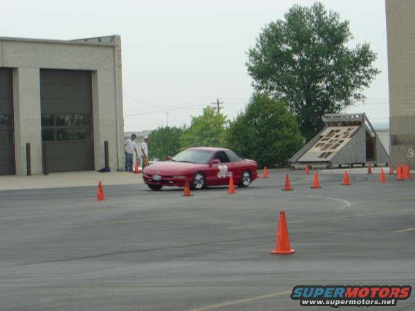 Red 1997 Ford Probe on asphalt course with orange cones