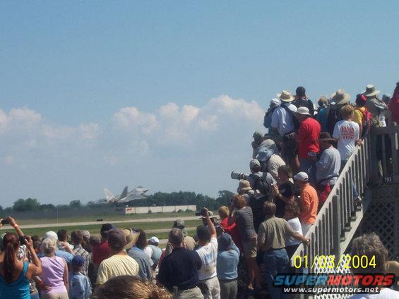 Crowd watches fighter jet take off from runway