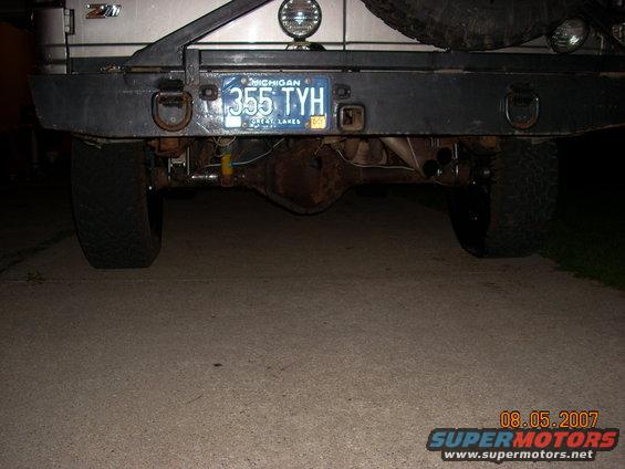 Rear view of a vehicle showing the axle, bumper, and Michigan license plate 355 TYH