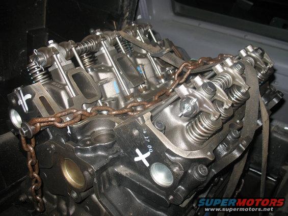 Engine block with rusty chain and straps, close-up view