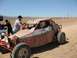 1992 Ford Bronco - A SCORE buggy with crew members attending to it in a desert-like environment under a clear blue sky.