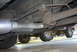 1994 Dodge Stealth - The underside of a vehicle reveals a recently installed exhaust system, with another vehicle partially visible behind it.