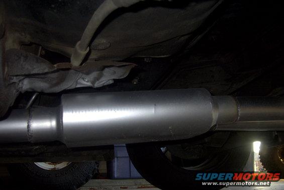Underside view of a vehicle's exhaust system with a new muffler and pipe
