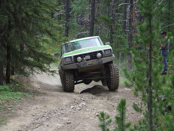 Green off-road truck on a dirt path, 1980s body style