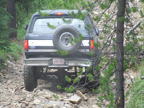 Ford Bronco on a rocky trail, spare tire mounted on the back